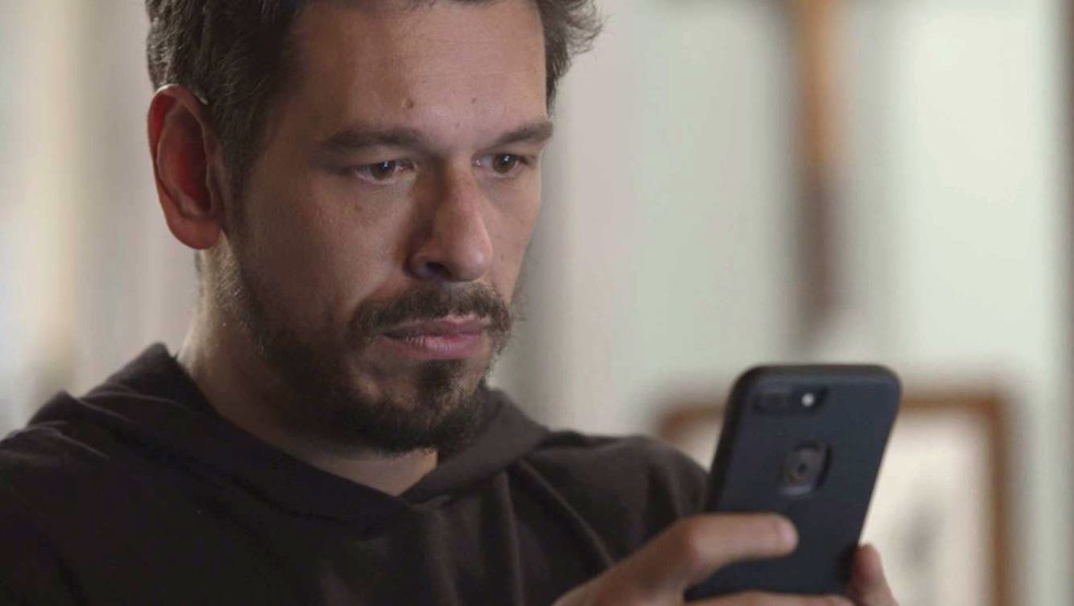 Alain recebe mensagem de número desconhecido em seu celular — Foto: TV Globo