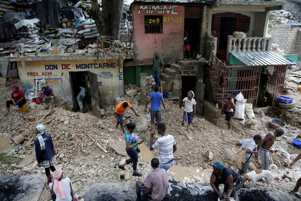 25 de agosto - Moradores caminham por uma rua afetada pela passagem da tempestade tropical Laura, em Porto Príncipe, Haiti — Foto: Andres Martinez Casares/Reuters