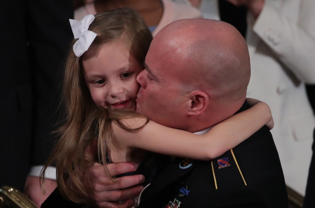 Townsend Williams, sargento norte-americano, abraça a filha ao aparecer de surpresa no discurso de Donald Trump na Câmara dos EUA. O militar estava no Afeganistão e foi apresentado pelo presidente nesta terça-feira (4) — Foto: Tom Brenner/Reuters