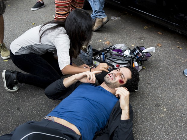 João Baldasserini é maquiado no chão. O que será que vai acontecer? (Foto: Ellen Soares / Gshow)