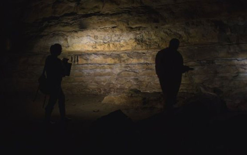 Acompanhada do marido fotógrafo, Genevieve von Petzinger explora a caverna de Cudon, na região espanhola da Cantábria (Foto: BBC/D. von Petzinger)