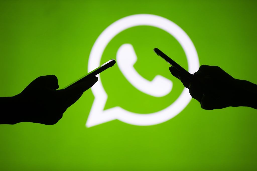 ANKARA, TURKEY - JULY 18 : People hold mobile phones in front of the logo of WhatsApp application in Ankara, Turkey on July 18, 2018. (Photo by Aytac Unal/Anadolu Agency/Getty Images) (Foto: Getty Images)