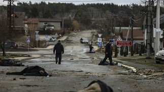 Cenas que chocaram o mundo: foto tirada em 02 de abril de 2022 mostra corpos de civis em uma rua de Bucha, a noroeste de Kiev, depois que o exército russo se retirou da cidade.  — Foto: RONALDO SCHEMIDT/AFP/02/04/2022