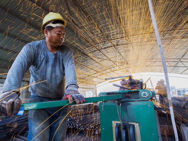 Trabalhador corta barras de ferro em contrução de ponte em Lianyungang (Foto: China Daily/Reuters)