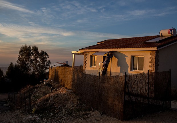 Homem faz reparos em casa em assentamento israelense na Cisjordânia (Foto:  Chris McGrath/Getty Images)