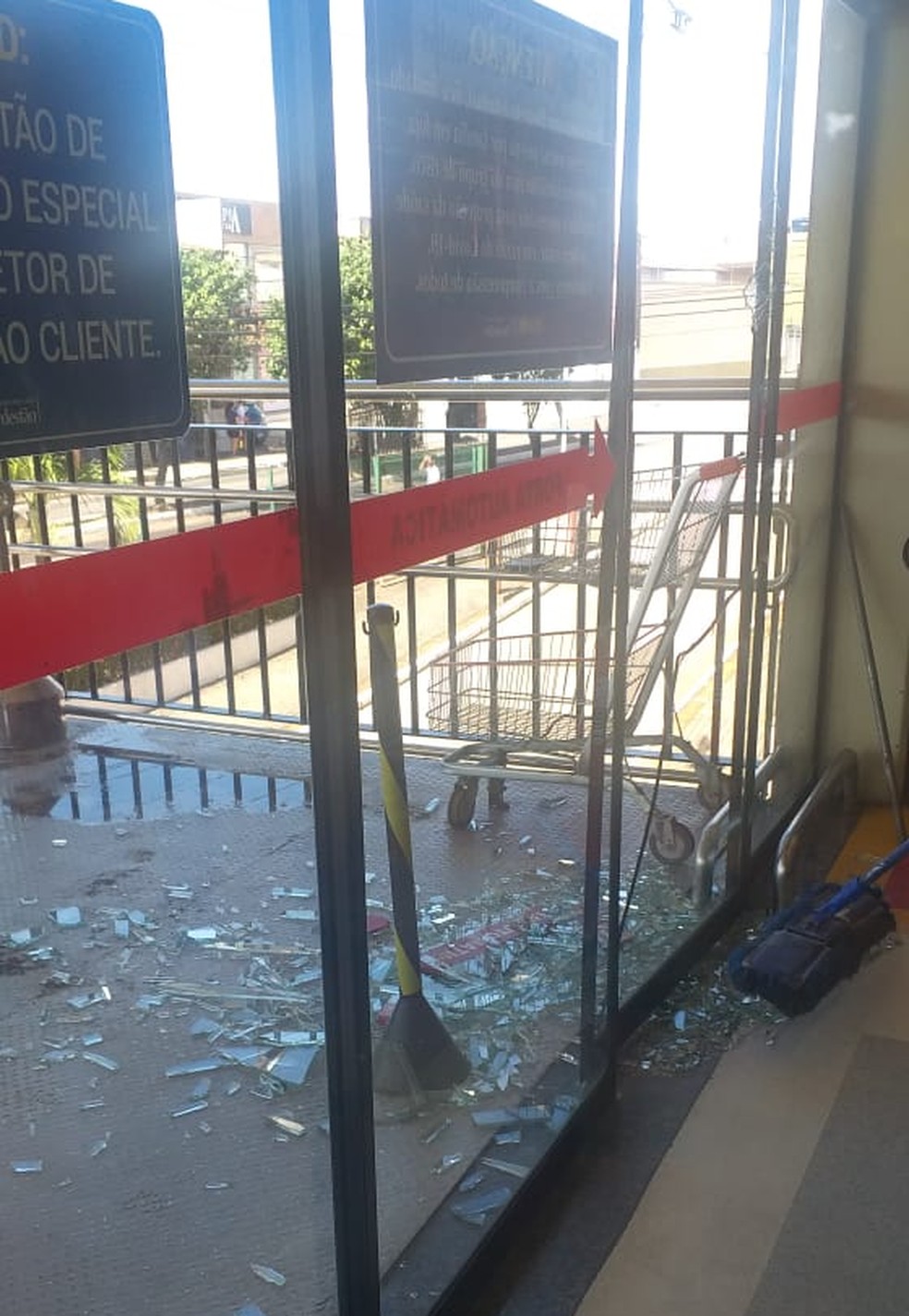 Porta de vidro foi quebrada por criminoso durante fuga em supermercado da Grande Natal. — Foto: Cedida