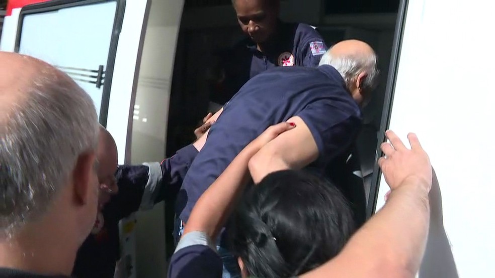O Coronel Lima é colocado em uma ambulância do Samu (Foto: GloboNews/Reprodução)