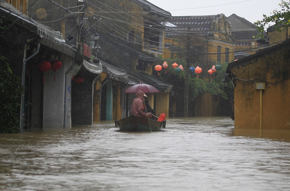 Habitantes da cidade histórica de Hoi An, tombada pela Unesco, usam barcos para se deslocar após passagem do tufão Damrey (Foto: Hau Dinh/AP)