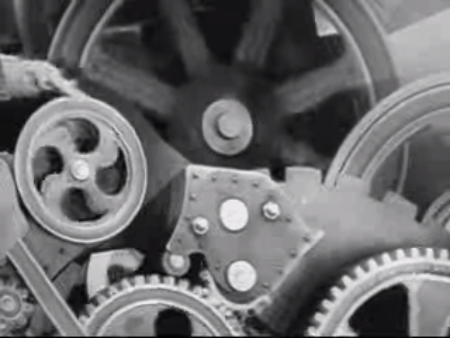 Chaplin cai nas engrenagens em 'Tempos Modernos' (Foto: Reprodução)