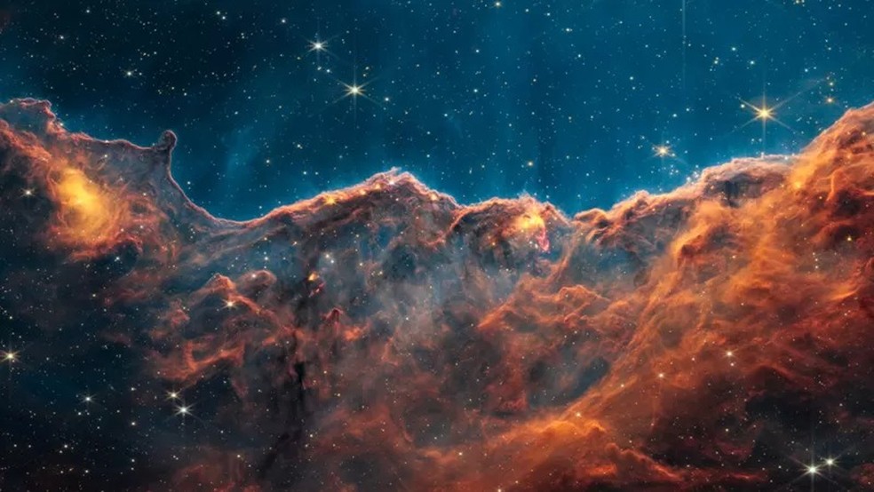 Os chamados "penhascos cósmicos" formam a beira de uma cavidade gasosa dentro da Carina, uma nebulosa formadora de estrelas — Foto: NASA/ESA/CSA/STSCI (BBC News)