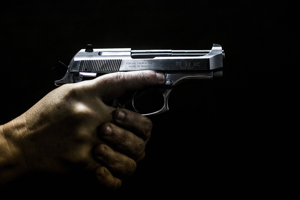 Homem segura uma arma em um clube de tiro em São Gonçalo, no Rio de Janeiro — Foto: Daniel Ramalho/AFP/Arquivo