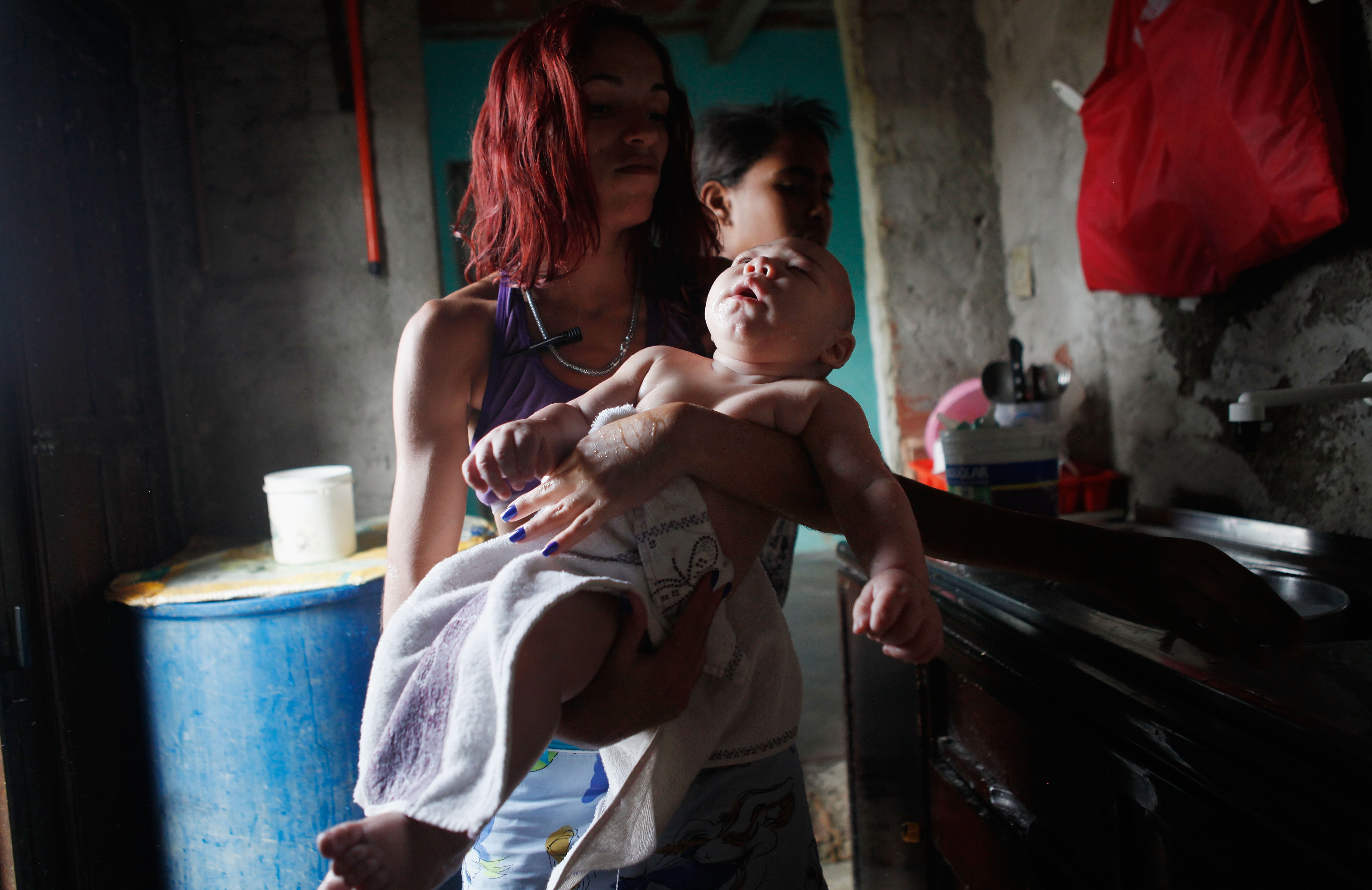 David Henrique Ferreira, que nasceu com microcefalia, é carregado por sua tia Sterfany Ferreira após um banho em 01 de fevereiro de 2016, em Recife, Pernambuco (Foto: Mario Tama/Getty Images)