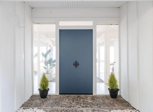 PORTA DE ENTRADA | Com o azul contrastando a tonalidade neutra do local e maçaneta diferenciada, a porta de entrada se torna quase uma peça de decoração (Foto: Reprodução / Neue Focus/Sotheby's International Realty)