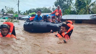 Equipes de resgate evacuam pessoas devido a fortes causadas pela tempestade tropical Nalgae em Parang, província de Maguindanao. Delizamentos já mataram mais de 10 pessoas — Foto: AFP