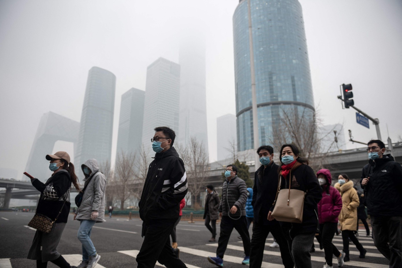 Pessoas caminham pelo centro de Pequim durante hora do rush