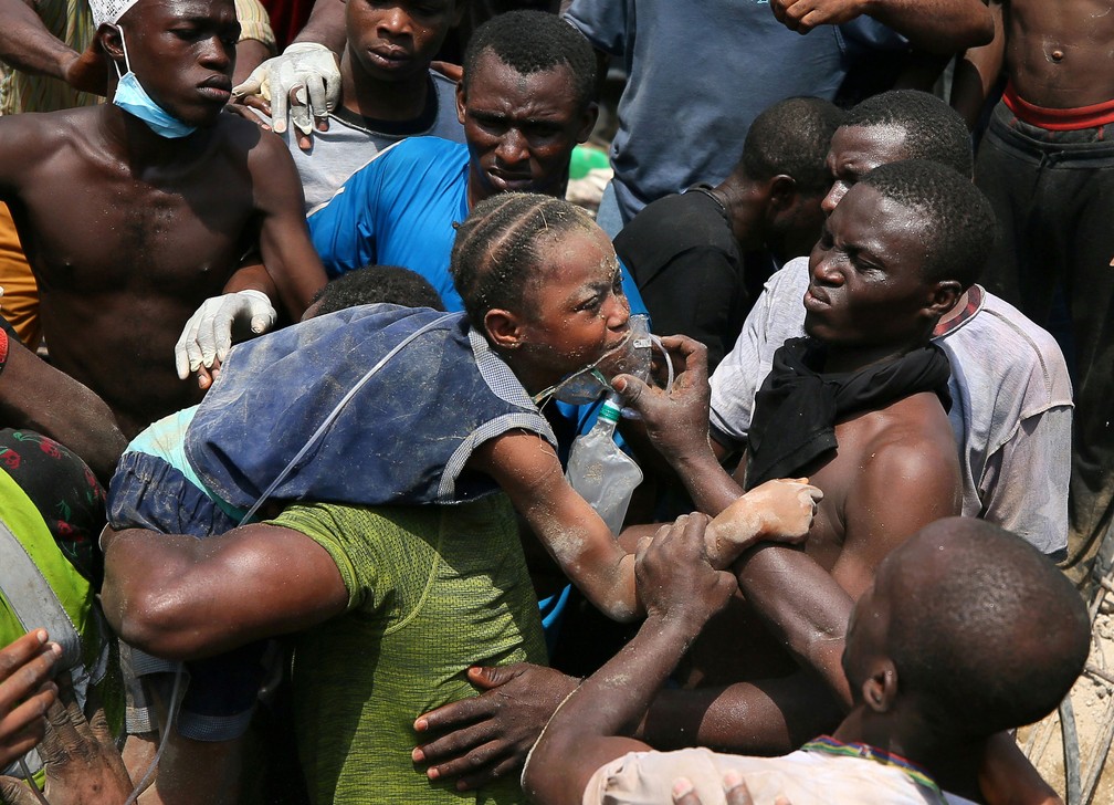Menina Ã© retirada de escombros apÃ³s prÃ©dio desmoronar em Lagos, na NigÃ©ria, nesta quarta-feira (13)  â€” Foto: Afolabi Sotunde/ Reuters