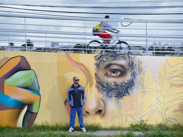 O Artista gráfico, AQI Luciano, diante de seus grafites na passarela da Ponte da Passagem (Foto: Edson Chagas/ A Gazeta)