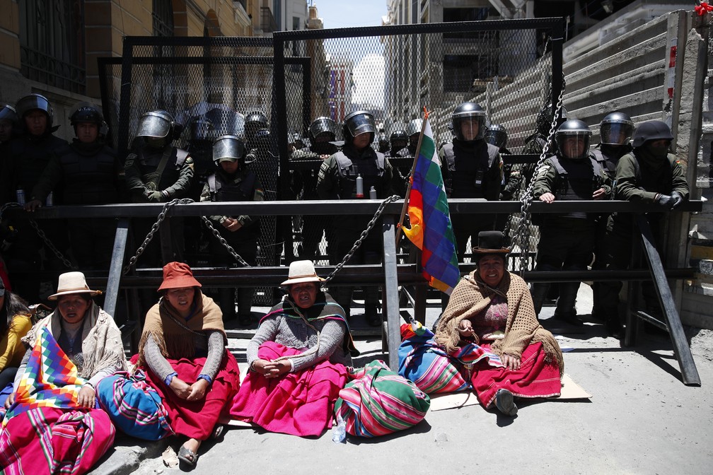 Apoiadoras de Evo Morales sentam em frente à polícia em La Paz, na Bolívia, nesta segunda-feira (18) — Foto: Natacha Pisarenko/AP Photo