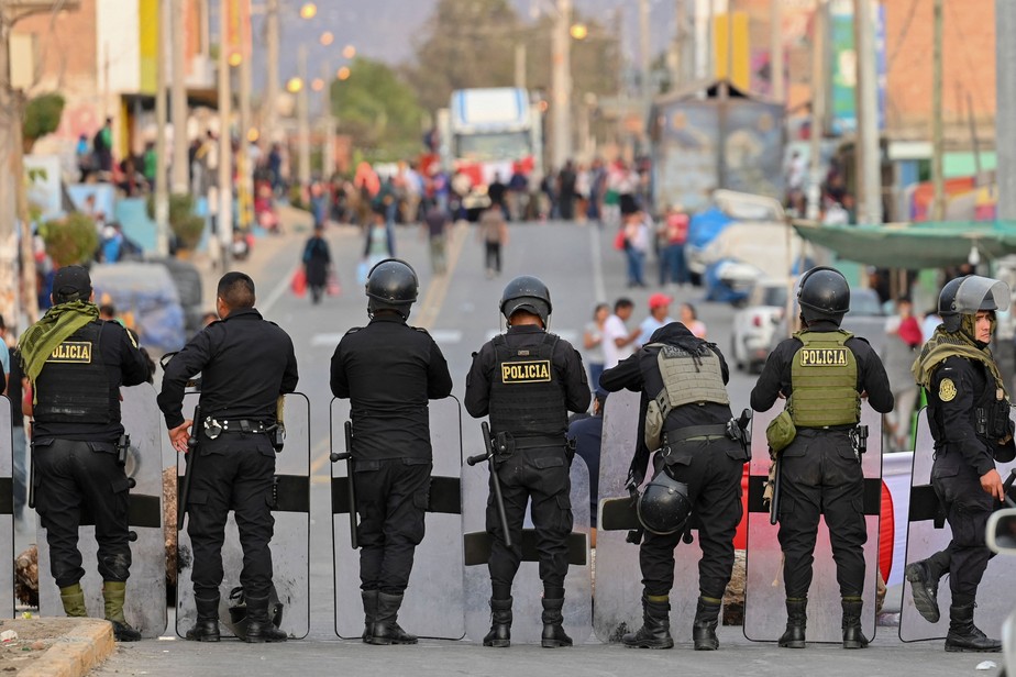 Policiais montam guarda em uma rua de Humay, Peru, depois de deter um comboio de manifestantes Chancas, da região central dos Andes, a caminho de Lima para participar de uma grande protesto contra a presidente Dina Boluarte
