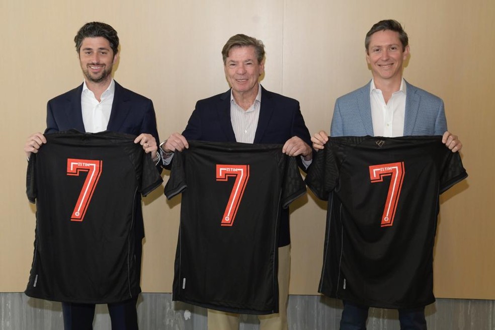 Josh Wander (sócio do 777), Jorge Salgado e Jorge Arciniegas (diretor de esportes do 777) posam com camisas do clube — Foto: Divulgação