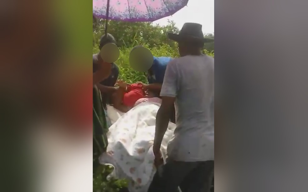 Grvida que passou mal  levada por vizinhos em carrinho de mo por causa de atoleiro em So Domingos, Gois  Foto: Reproduo/TV Anhanguera
