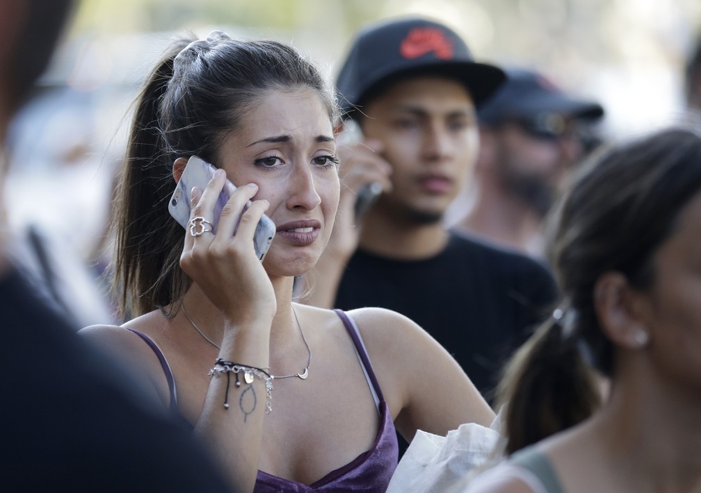 Mulher fala ao telefone próximo ao local onde atentado terrorista matou várias pessoas em Barcelona, na Espanha  (Foto: AP Foto/Manu Fernandez)