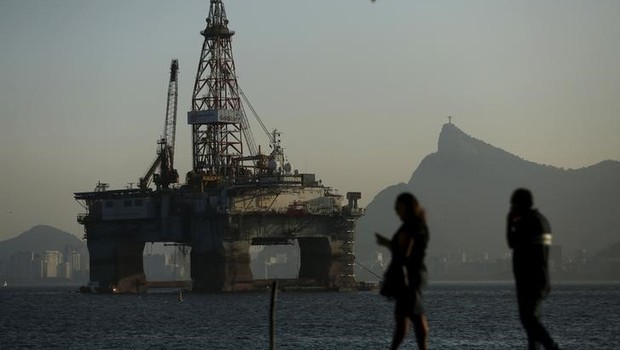 Pessoas passam por plataforma de petróleo em Niterói, no Rio de Janeiro - Brasil - Economia - Petróleo - produção - energia - Petrobras (Foto: Pilar Olivares/Reuters)
