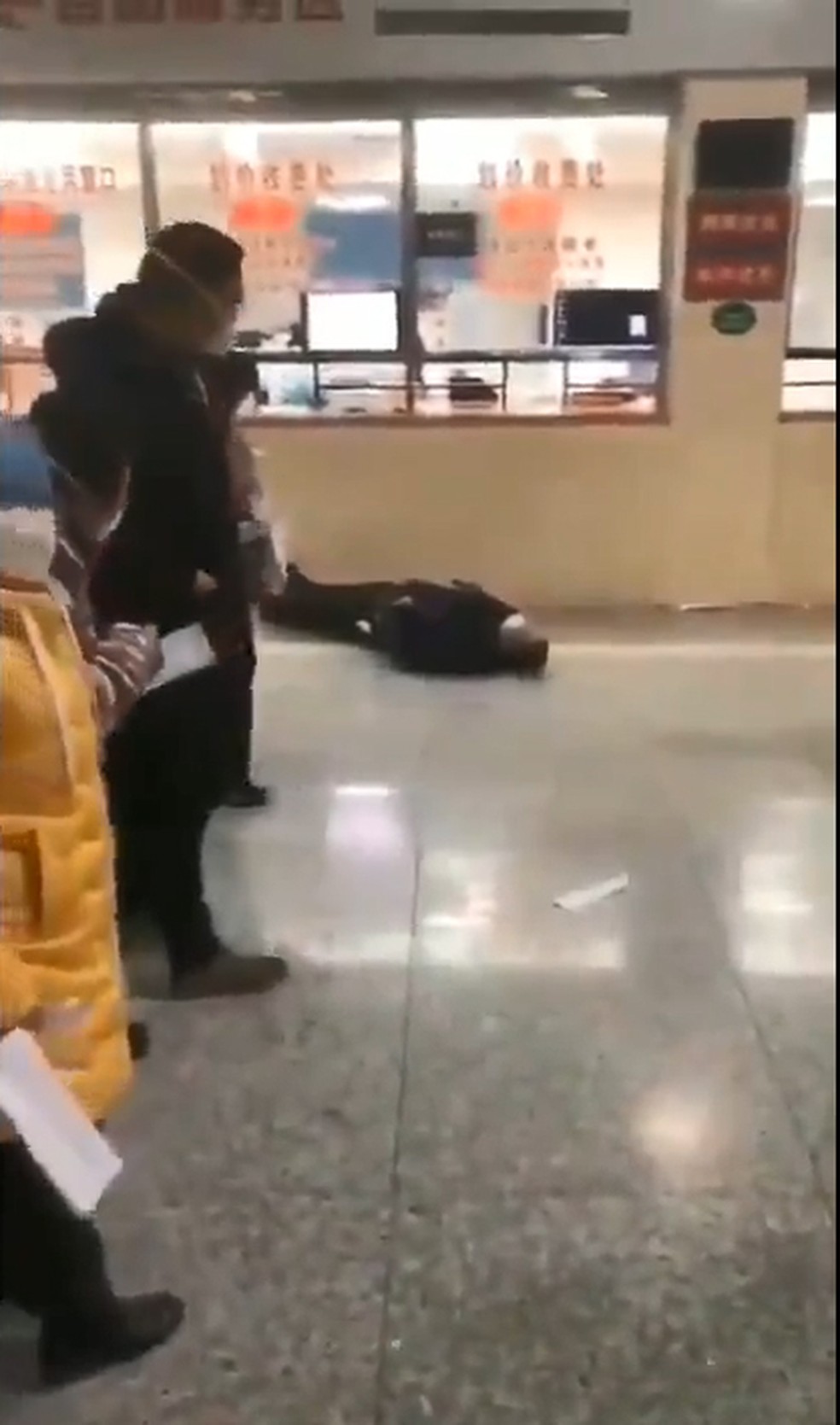 Vídeo mostra homem caído em frente a um vidro com inscrições — Foto: Reprodução