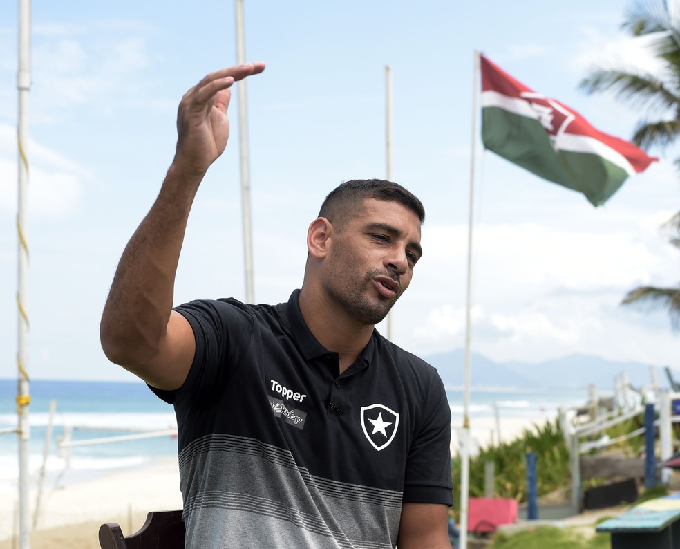 Diego Souza deu entrevista perto de uma bandeira do Fluminense, na Praia da Barra — Foto: André Durão/GloboEsporte.com
