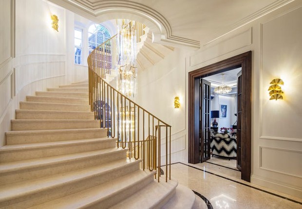 O salão principal possui uma escada de pedra e um lustre do chão ao teto (Foto: Sotheby's International Realty)