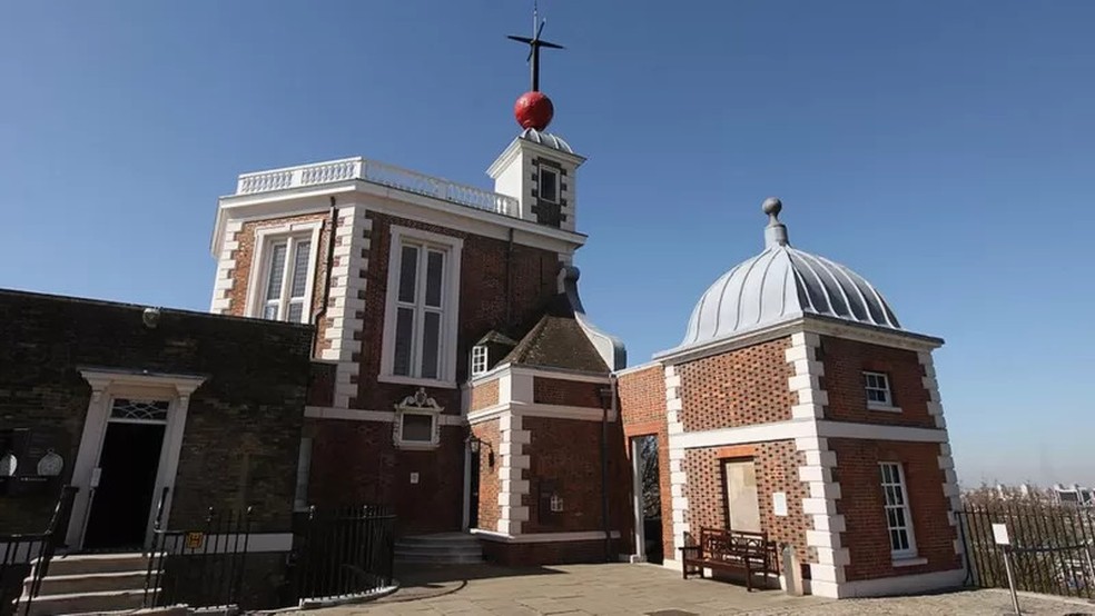 A bola vermelha do Observatório Real de Greenwich ainda é usada para anunciar a hora certa em Londres, caindo no mastro exatamente às 13h todos os dias — já o relógio Shepherd, no portão do observatório, marca a hora GMT para o público — Foto: Getty Images