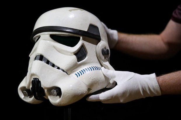 A prop store employee adjusts a screen matched Tantive IV Stormtrooper helmet from 1977 film Star Wars: A New Hope (estimate ??120-180,000), during a preview of the forthcoming film and television memorabilia auction at the Prop Store head office near Ric (Foto: PA Images via Getty Images)