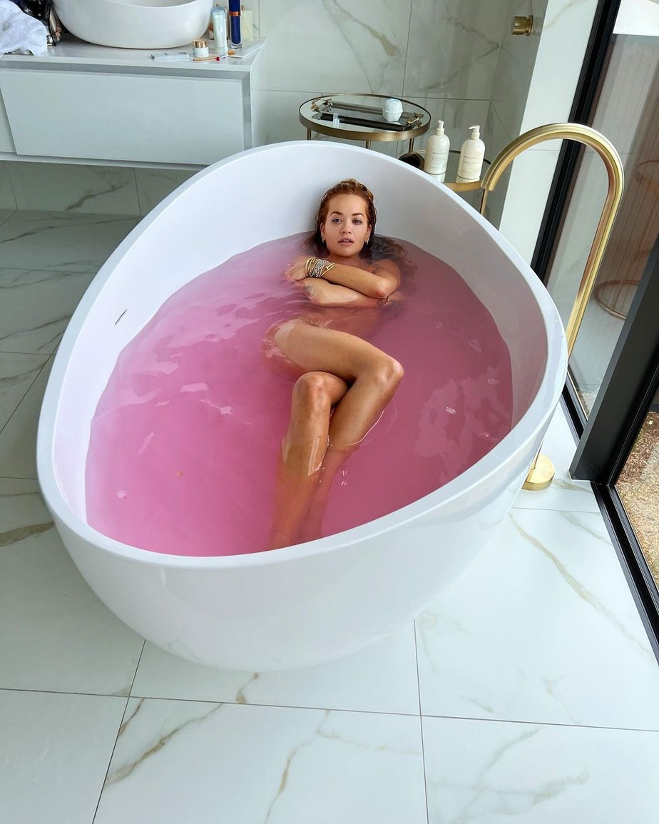 Rita Ora surge na banheira  com água cor-de-rosa