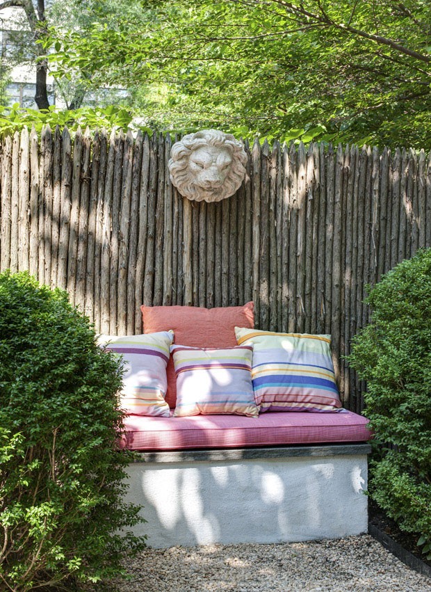 Throw pillows from Les Toiles du Soleil in a garden designed by Miranda Brooks using plants beloved by Leslie Mason’s mother; peonies, roses, clematis, lavender, lilac and forget-me-nots, at Mason's home in the Greenwich Village neighborhood of New York,  (Foto: Bruce Buck / The New York Times)