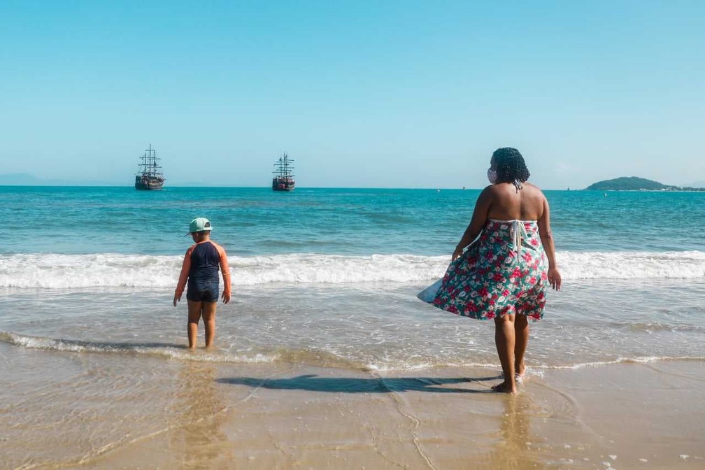 Theo e a mãe Martina na Praia de Canasvieiras em Florianópolis — Foto: Tiago Ghizoni/ NSC 