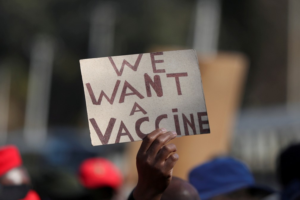 Pessoa segura cartaz pedindo vacinas contra a Covid-19 durante protesto em Pretória, na África do Sul, em 25 de junho de 2021 — Foto: Siphiwe Sibeko/Reuters