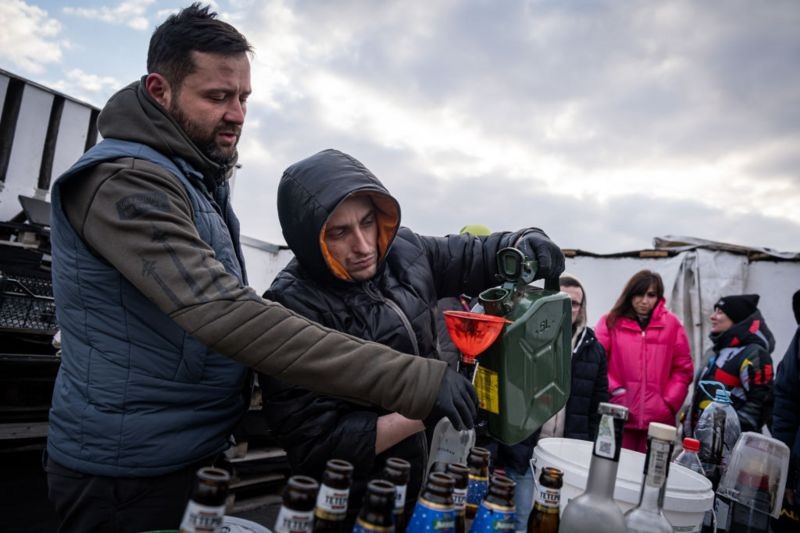 Civis mostram como preparar coquetéis molotov no terraço de um cinema em Lviv, na Ucrânia (Foto: Getty Images via BBC News)