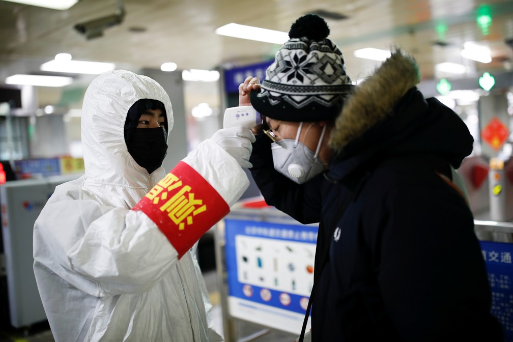 Passageiro do metrô de Pequim passa por medição de temperatura, em 28 de janeiro de 2020 — Foto: Carlos Garcia Rawlins/Reuters
