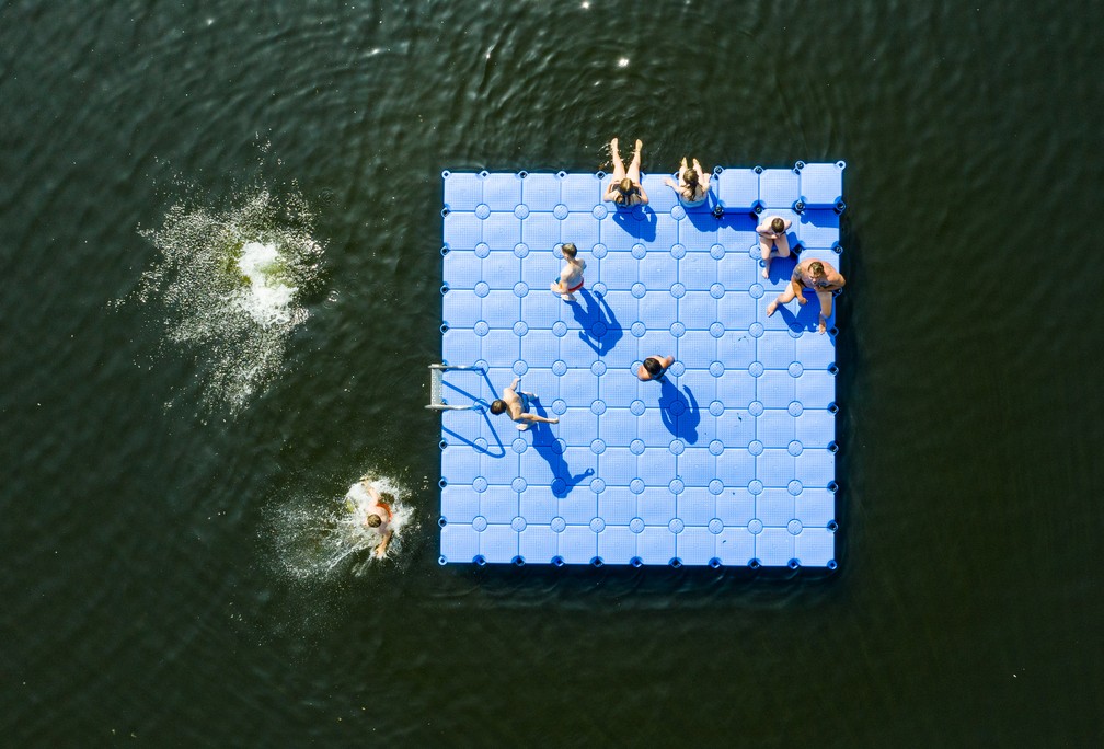 Foto aérea do dia 25 de julho mostra pessoas tomando banho ao redor de uma plataforma em um lago em Hanover, no norte da Alemanha, onde a previsão era de que as temperaturas alcançassem os 39ºC. — Foto: Christophe Gateau / dpa / AFP