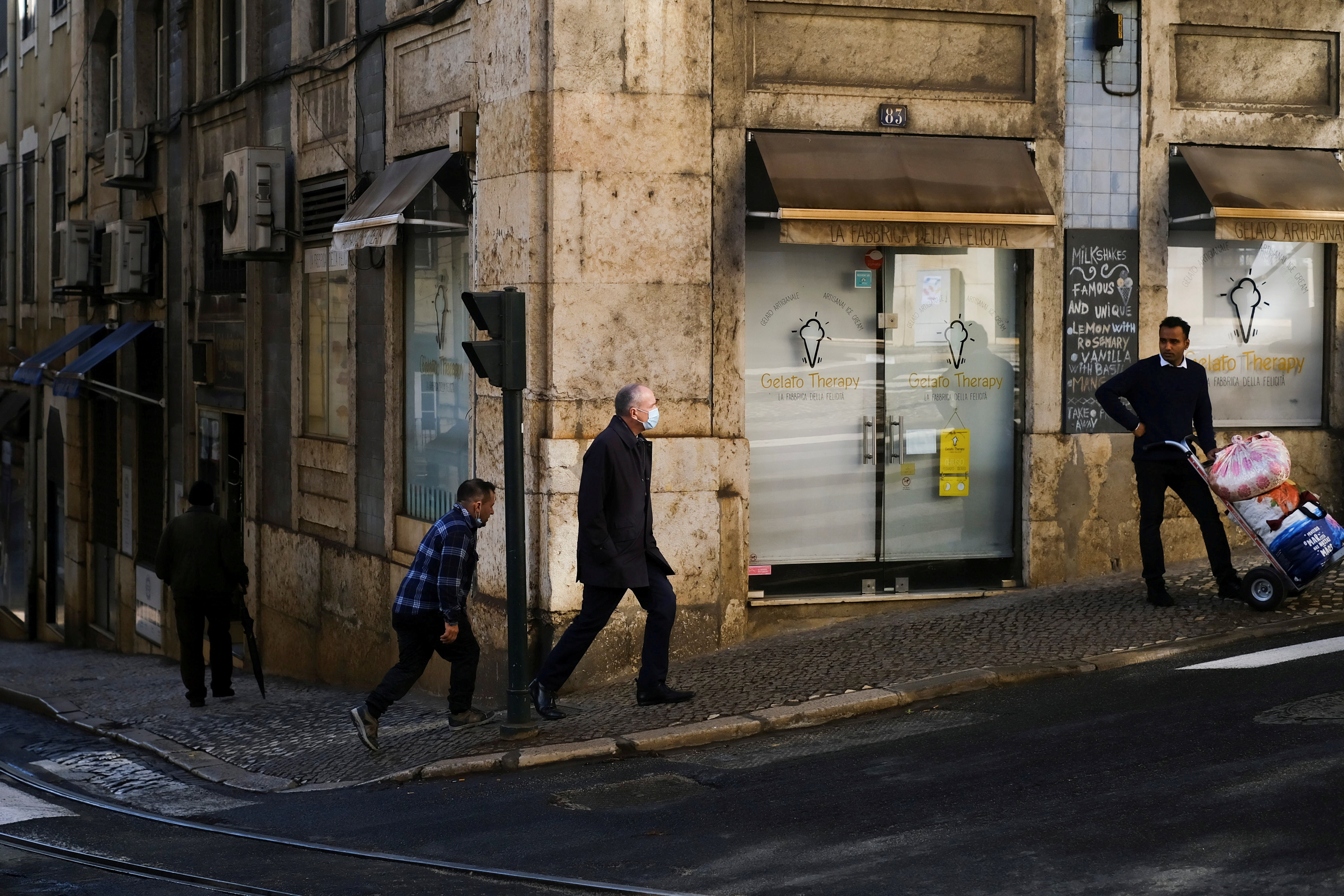 Pedestres caminham em uma calçada de Lisboa