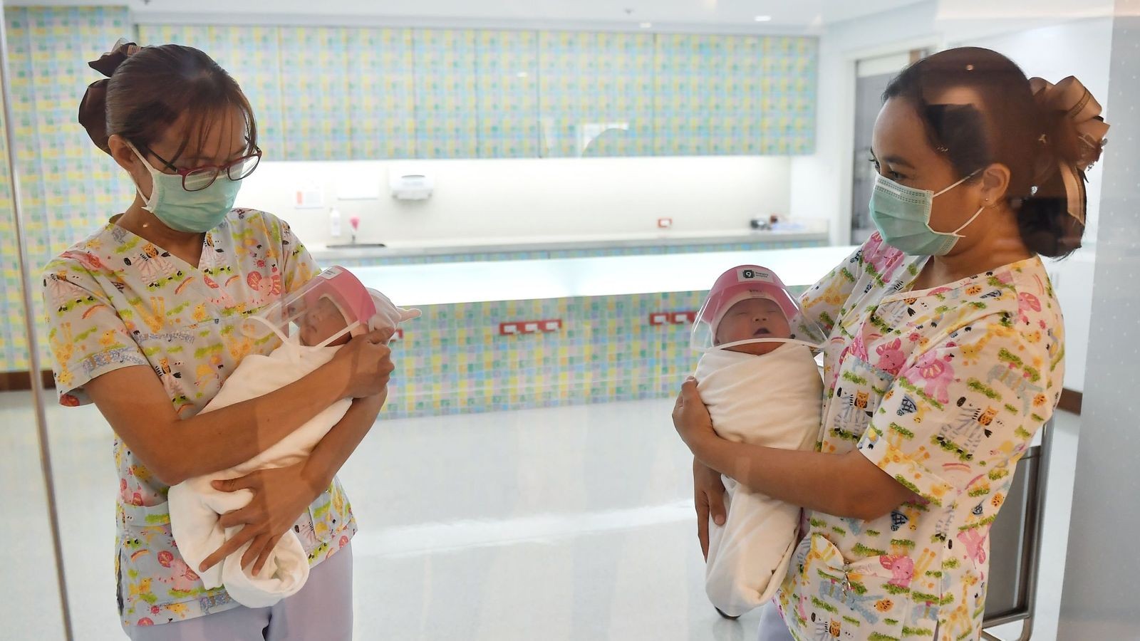 Enfermeiras mostram recém-nascidos aos familiares na Tailândia (Foto: Reprodução Twitter @Athit_P)