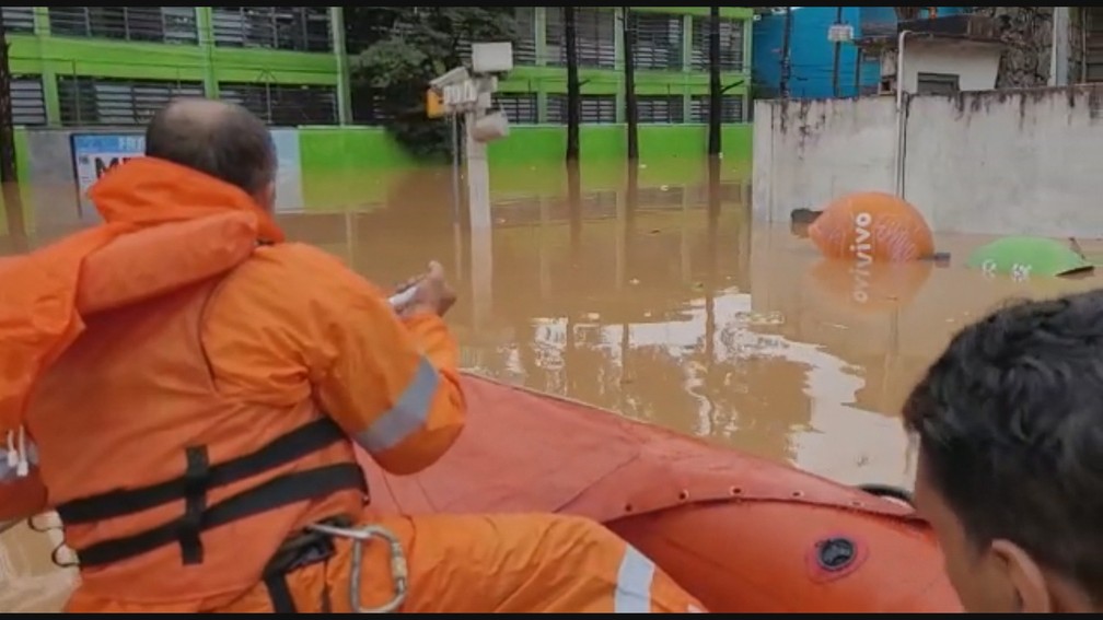 Equipes usam bote para resgate após rios transbordarem e alagarem região central de Franco da Rocha, na Grande SP — Foto: Reprodução/GloboNews