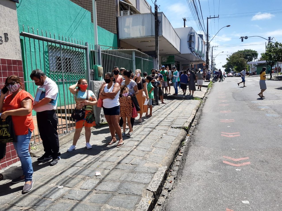Fila de pessoas que aguardam atendimento na agência do Alecrim — Foto: Lucas Cortez/Inter TV Cabugi