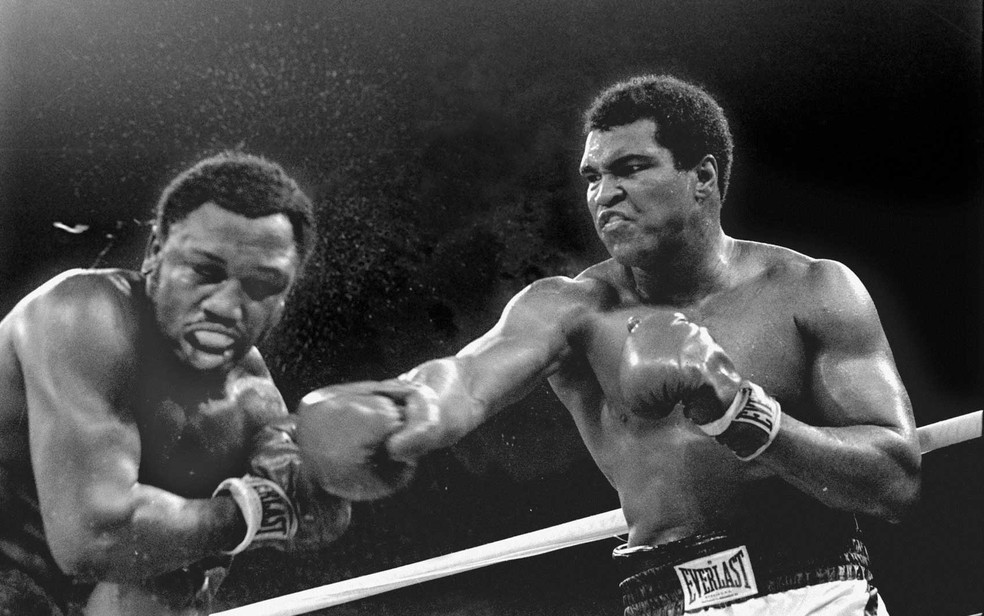 Muhammad Ali acerta o rosto de Joe Frazier em luta realizada em 1975 — Foto: Mitsunori Chigita via AP