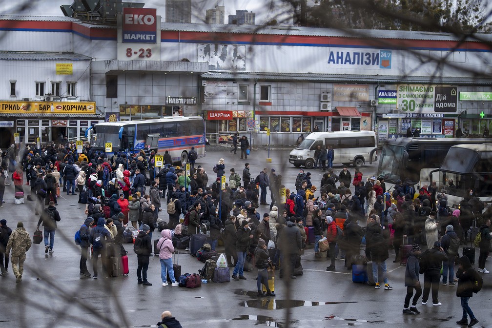 Pessoas tentam entrar em ônibus para deixar Kiev, Ucrânia, nesta quinta-feira (24) — Foto: Emilio Morenatti/AP