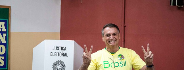 O presidente Jair Bolsonaro faz o 'v' de vitória ao votar na Vila Militar. — Foto: Hermes de Paula