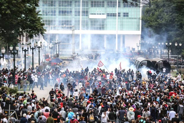 O momento em que policiais começaram a usar bombas de gás em frente à Assembleia Legislativa do Paraná (Foto: Reprodução / Facebook APP Sindicato)