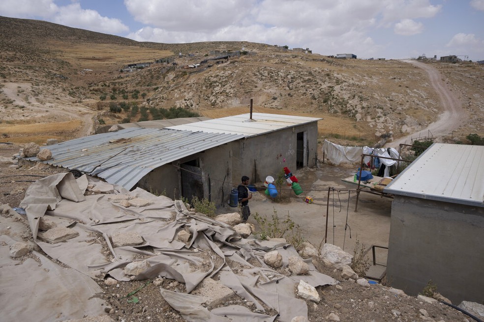 Arquivo - Um homem palestino entra em sua casa na comunidade Jinba, Masafer Yatta, na Cisjordânia, sexta-feira, 6 de maio de 2022 — Foto: AP Foto/Nasser Nasser