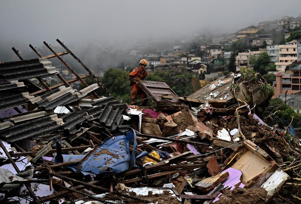 Bombeiro trabalha na busca por vítimas após deslizamento em Petrópolis (RJ), nesta quarta (16) — Foto: Carl de Souza/AFP