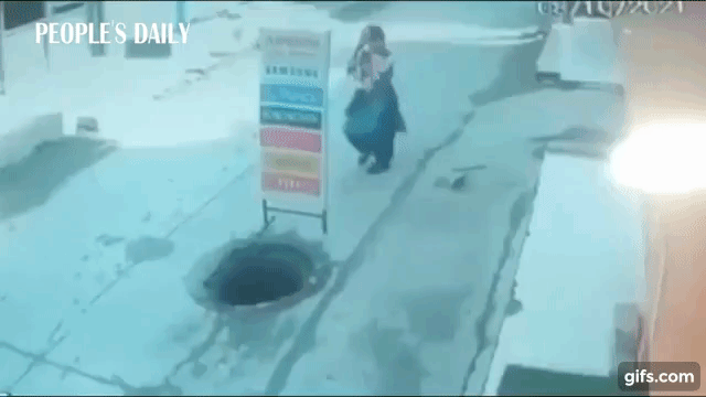 Mulher cai com bebê de colo em bueiro  (Foto: Reprodução YouTube )
